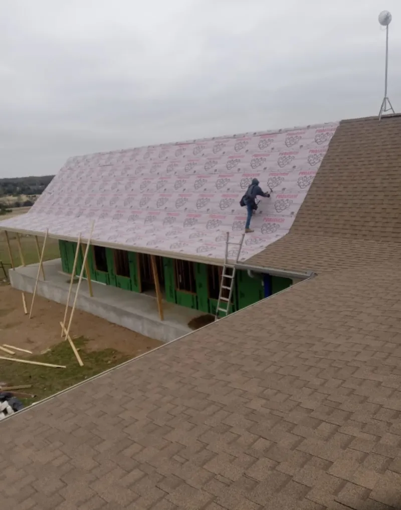Worker preparing underlayment for a metal roof installation in Grant-Valkaria
